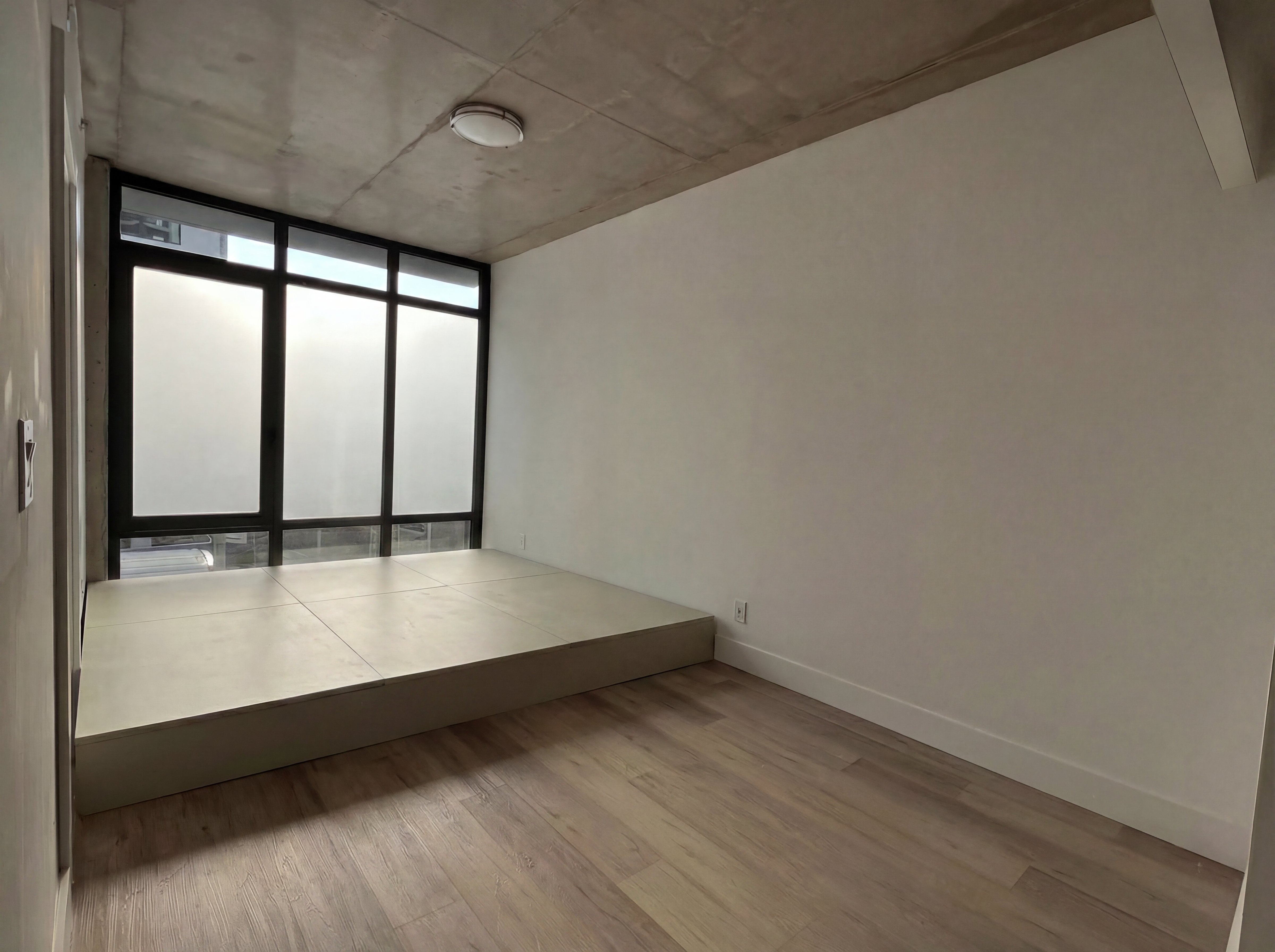 Storage platform — lid closed, a raised panel landing under a window wall
